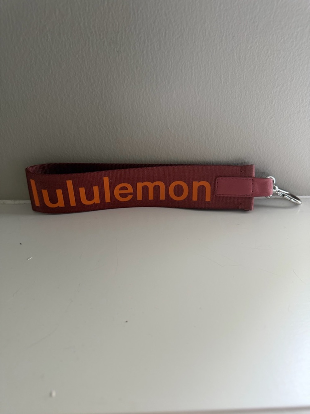 lululemon burgundy wristlet with orange logo. NWOT
